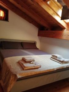 un letto in una camera con travi in legno di Mansarda Chanoux CIR n 0027 a Châtillon
