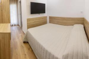 a bedroom with a bed and a flat screen tv at B&B Loricaly in Lorica