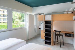 1 dormitorio con litera, escritorio y litera en Riva Rooms & Studios - Check-In 24hr, en Locarno