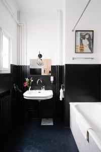 een zwart-witte badkamer met een wastafel en een bad bij Smartflats Design - Esplanade in Brussel