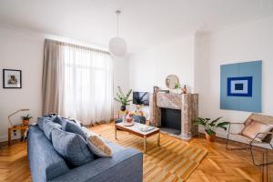 a living room with a blue couch and a fireplace at Smartflats Design - Esplanade in Brussels