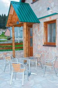 einem Picknicktisch und Stühlen vor einem Gebäude in der Unterkunft Guesthouse MG in Žabljak