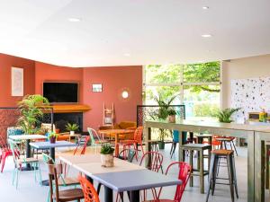 een restaurant met tafels en stoelen en een open haard bij Greet Hôtel Castres Saix in Saix
