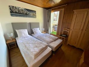 two twin beds in a room with a window at Tignes duplex 8-10 p avec parking in Tignes