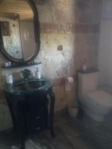 a bathroom with a sink and a toilet and a mirror at Старата баkалия The old grocery, guest rooms in Balchik