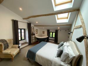 a bedroom with a large bed and a bath tub at Maison Mûrier in Fayssac