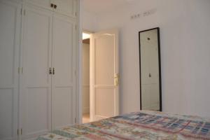 1 dormitorio con cama y espejo en CASA NORI - Apartamento a 4 minutos de la playa, en Tías