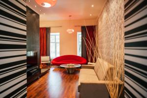 a living room with a couch and a red chair at D31 Hotel in Odesa