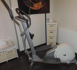 an exercise bike in a room with a table at Hotel No Minoé in Locminé