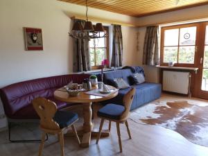 een woonkamer met een paarse bank en een tafel bij Ferienwohnung Sonnenplatzl in Reit im Winkl