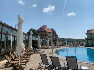 ein Pool mit Liegestühlen und Sonnenschirmen neben einem Resort in der Unterkunft Hotel Eden in Şimian