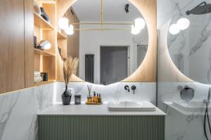 La salle de bains est pourvue d'un lavabo et d'un miroir. dans l'établissement Choya Apartments, à Poznań