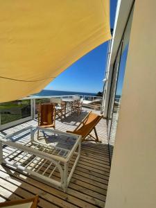 terraza con sillas y mesa en el balcón en Casa do Cruceiro surfing Costa da Morte en Cayón