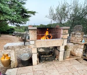 a stone pizza oven with a fire in it at B&B La Grave in Noci