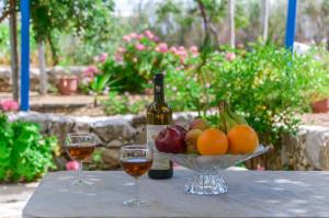einen Tisch mit einer Schale Obst und einer Flasche Wein in der Unterkunft Golden Beach Glyfada Apartments in Kastraki Naxos