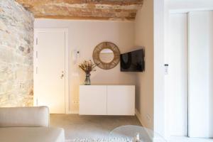 sala de estar con sofá blanco y espejo en Bruma Boutique Apartment, en Girona