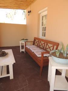 a room with a bed and two tables and a window at Stone Haven at Nieu Bethesda in Nieu-Bethesda