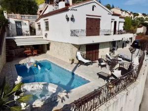 a villa with a swimming pool in front of a house at Chambres chez l'habitant Villa l'Île aux Anges in Saint-Andre-de-la-Roche