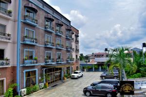 um edifício com carros estacionados num parque de estacionamento em Oak Haven Hotel & Suites em Port Harcourt