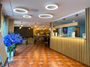 un vestíbulo con un bar y flores azules en un jarrón en Somriu Hotel Vall Ski en Incles