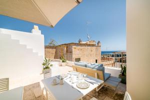 a table and chairs on a balcony with a view of the ocean at Tre Archi Suite & Relais in Polignano a Mare