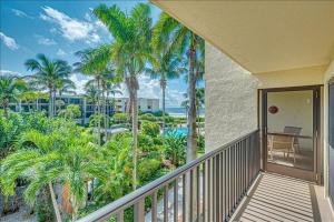 een balkon met palmbomen en uitzicht op de oceaan bij Sea Oats 241 Apartment in Boca Grande