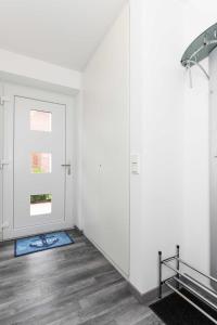 a white room with a door and a window at Ferienhaus Ella in Dornumersiel
