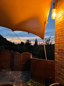 ガーヴィにあるBella Gavi - natura e relaxのパティオ(傘付)から夕日を望めます。