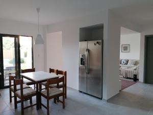 a kitchen with a table and a stainless steel refrigerator at Endless Summer Pool Flat in Ixia