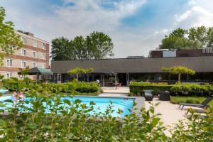 a courtyard with a swimming pool in front of a building at Novotel Rotterdam - Schiedam in Schiedam