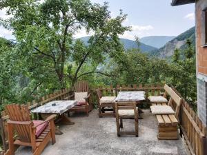 a patio with wooden tables and chairs with mountains in the background at MIMA in Jajce