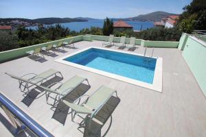 a swimming pool with lounge chairs and a swimming pool at Apartments Delta in Trogir