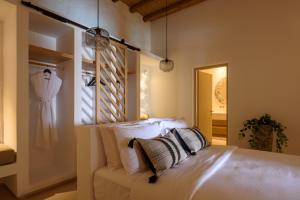 a bedroom with a bed and a dress hanging on a wall at Este Luxury Suites in Fira