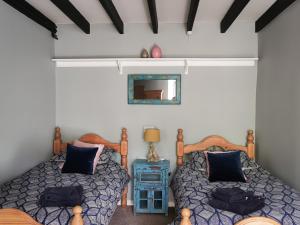 Un pat sau paturi într-o cameră la Wellstone Cottages - Jasmine