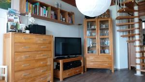 a living room with a television and wooden cabinets at Ferienhaus Rhönblick in Bischofsheim an der Rhön