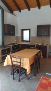 a large kitchen with a wooden table and chairs at Fattoria Armonia in Stilo