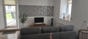 a living room with a couch and a flat screen tv at Ferienwohnung Dick Schwarzenberg in Schwarzenberg