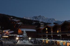 a christmas tree in front of a building with lights at PIERRA MENTA ARC 1800 Studio Appartement - 5 per in Arc 1800
