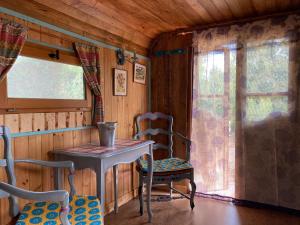 einen Tisch und Stühle in einem Zimmer mit Fenster in der Unterkunft La Roulotte Cavalière, au cœur d'une manade en Camargue in Mas-Thibert