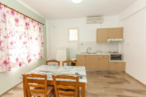 a kitchen with a table and chairs in a room at Lido Apartments Tolo in Tolo