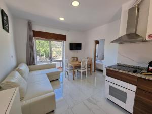 a living room with a couch and a kitchen at Vale do Sol in Albufeira