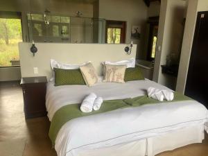 a bedroom with a large bed with towels on it at Kgorogoro Lodge in Pilanesberg