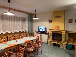 een eetkamer met tafels, een tv en een open haard bij Chata SOŠS Vrátna Dolina in Terchová