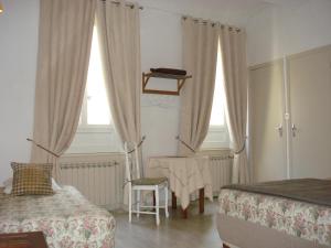 1 dormitorio con 2 camas, silla y mesa en Le 18 by Benson, en Bollène