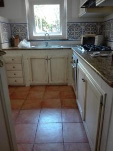 una cucina con armadietti bianchi e pavimento piastrellato di ISCHIA è Vita ! a Ischia