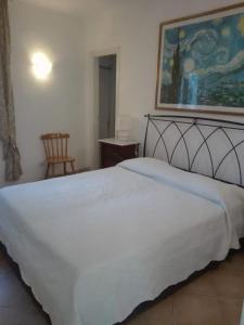 una camera da letto con un letto bianco e un dipinto sul muro di ISCHIA è Vita ! a Ischia