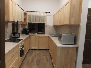 a kitchen with wooden cabinets and a microwave at APUSENI HOLIDAYS in Răchiţele