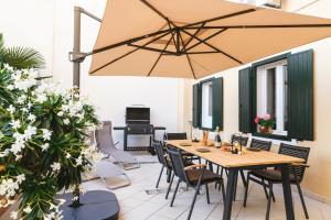 a patio with a table and chairs and a large umbrella at Apartment Park Piran in Piran