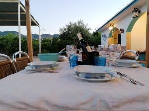 einen Tisch mit Tellern und Gläsern sowie eine Flasche Wein in der Unterkunft VILLA LOS ARCOS in Málaga
