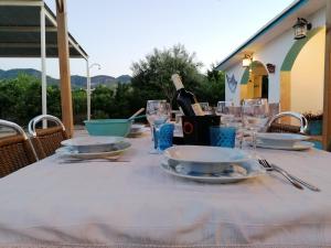 a table with plates and glasses and a bottle of wine at VILLA LOS ARCOS in Málaga